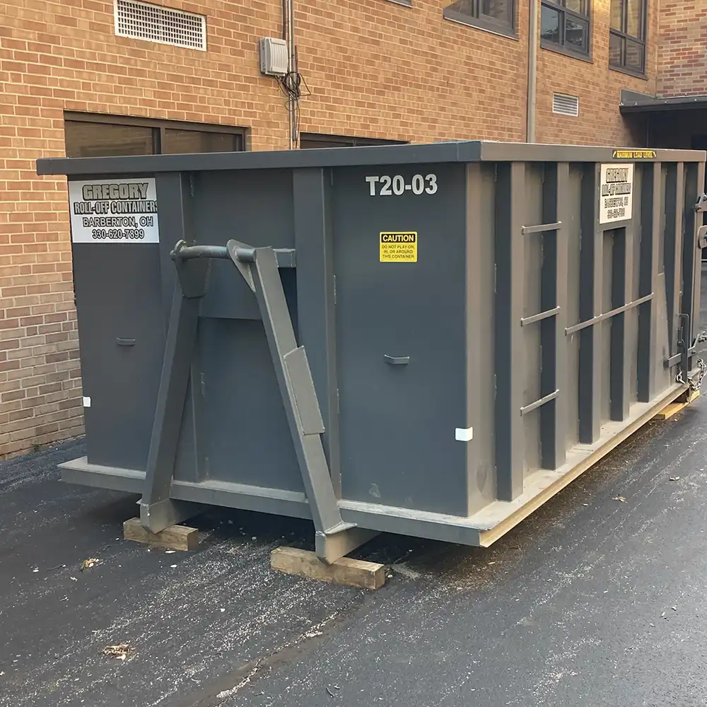 A gray 20-yard dumpster rental parked in front of a school building in Akron, Ohio.