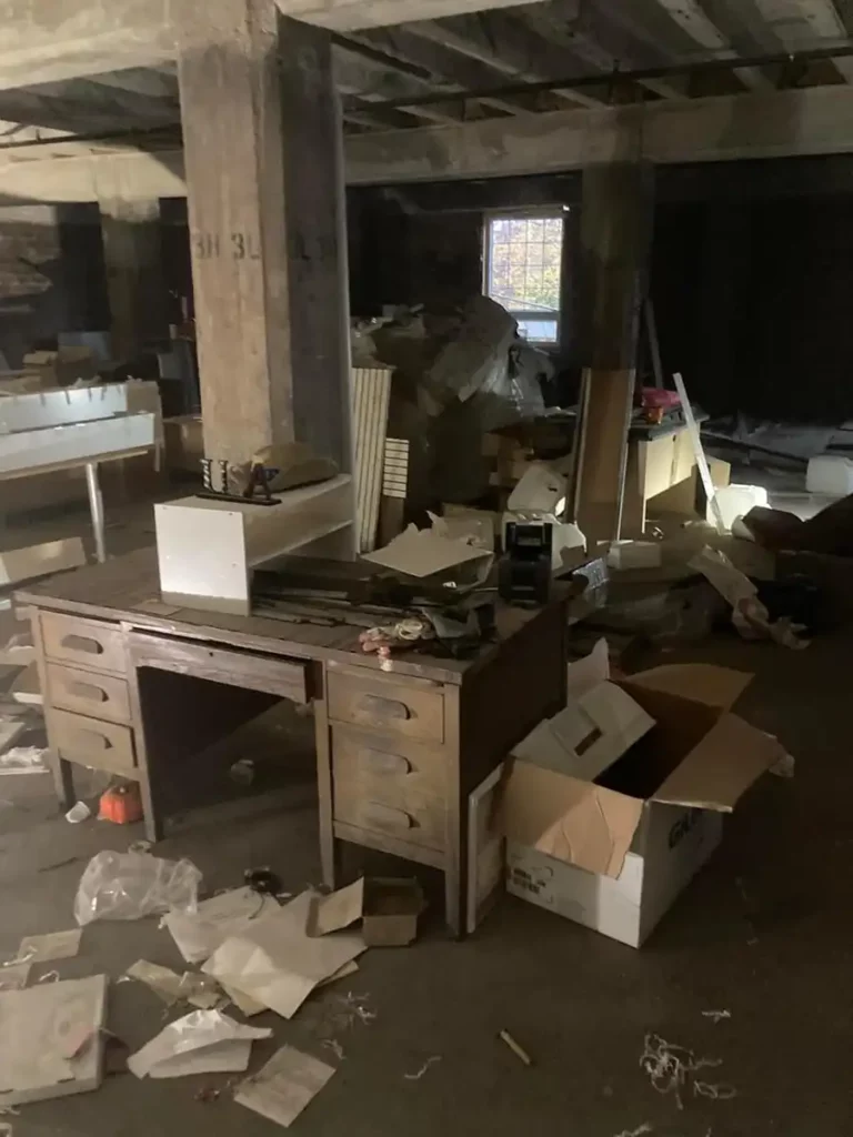 A room with a desk, boxes, and clutter that needs clean-out services in Akron.