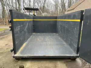 A black dumpster rental truck sitting on a driveway.